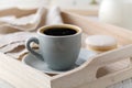 Cup of coffee and macaron cakes on tray on white wooden table Royalty Free Stock Photo