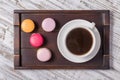 Cup of coffee and macaron cakes on tray on white wooden table. Lifestyle concept. Royalty Free Stock Photo