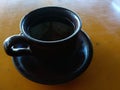 A cup of coffee made of ceramic on a yellow table