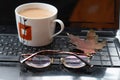 Cup of coffee, maple leaf and glasses on laptop keyboard, earnings on the Internet, freelancer