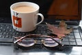 Cup of coffee, maple leaf and glasses on laptop keyboard, earnings on the Internet, freelancer Royalty Free Stock Photo