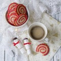 Cup of coffee with a marshmallow snowman and cookies in the form of a spiral in the Christmas table. Cozy winter breakfast. New Ye