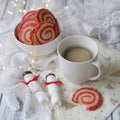 Cup of coffee with a marshmallow snowman and cookies in the form of a spiral in the Christmas table. Cozy winter breakfast. New Ye