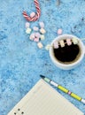 Cup with coffee and marshmallows, blank open notebook with pen on abstract blue background. Top view. Flat mockup. space for text Royalty Free Stock Photo