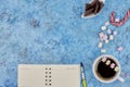 Cup with coffee and marshmallows, blank open notebook with pen on abstract blue background. Top view. Flat mockup. space for text Royalty Free Stock Photo