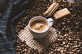 Cup of coffee in the middle of coffee beans with biscuits and tablecloth. Grained product. Hot drink. Close up. Harvesting. Natura Royalty Free Stock Photo