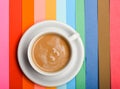 Cup of coffee with milk or cappuccino beverage on colorful as rainbow background. Dose of energy concept. Drink with