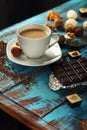 Cup of coffee with milk, chocolate bar and variety candies Royalty Free Stock Photo