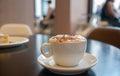 Cup of coffee with milk foam and cake in cafe Royalty Free Stock Photo