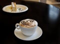Cup of coffee with milk foam and cake in cafe Royalty Free Stock Photo