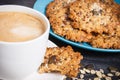 Cup of coffee with milk and fresh baked oatmeal cookies with honey and healthy seeds. Delicious crunchy dessert Royalty Free Stock Photo