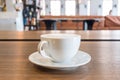 A cup of coffee with milk froth on wooden table in modern cafe