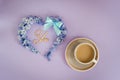 Cup of coffee with milk and heart made from hyacinth flowers on purple background. Royalty Free Stock Photo