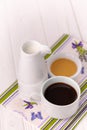 A cup of coffee, milk in a jar and honey in a bowl on a colorful napkin Royalty Free Stock Photo