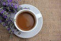 Cup of coffee with milk and lavender flowers on burlap fabric texture with copy space. Royalty Free Stock Photo