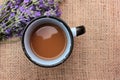 Cup of coffee with milk and lavender flowers on burlap fabric texture with copy space. Royalty Free Stock Photo