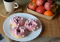 Cup of coffee with milk and three donuts with pink icing on a white plate. Royalty Free Stock Photo