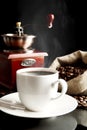 Cup of coffee with mill,bag full of coffee beans on black Royalty Free Stock Photo