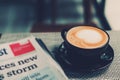 A cup of coffee and a newspaper of coffee on a wooden table Royalty Free Stock Photo