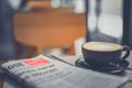 A cup of coffee and a newspaper of coffee on a wooden table Royalty Free Stock Photo