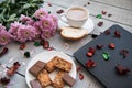 A Cup of coffee,note book , cracker, cookie, biscuit, lupins flowers on a wooden table. Royalty Free Stock Photo