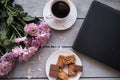 A Cup of coffee,note book , cracker, cookie, biscuit, lupins flowers on a wooden table. Royalty Free Stock Photo