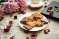 A Cup of coffee,note book , cracker, cookie, biscuit, lupins flowers on a wooden table. Royalty Free Stock Photo