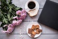 A Cup of coffee,note book , cracker, cookie, biscuit, lupins flowers on a wooden table. Royalty Free Stock Photo