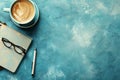 Cup of Coffee, Notebook, Eyeglasses, and Pen on Blue Background Flat Lay Workspace Composition Royalty Free Stock Photo