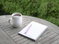 Cup of coffee with notebook and pen on top of table Royalty Free Stock Photo