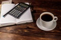 Cup of coffee and notepad with dollars, pencil and calculator on wooden desk. Financial concept Royalty Free Stock Photo