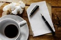 Cup of coffee with notepad, pen and crumpled paper Royalty Free Stock Photo