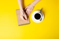 Cup of coffee, notepad, pencil, female hands