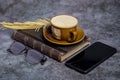 A cup of coffee, an old book , glasses, and a phone on the table Royalty Free Stock Photo