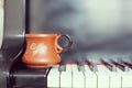 Cup of coffee on an old piano keyboard while composing. Evening time and some sun rays. Coffee mug on the piano keyboard