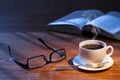 Cup of coffee, open book and glasses on a desk. Royalty Free Stock Photo