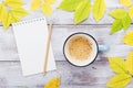 Cup of coffee, open empty notebook and autumn leaves on vintage wooden table top view. Cozy breakfast. Fall bucket list. Flat lay