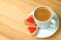 Cup of coffee and a pair of heart shaped cookies on wooden table with copy space Royalty Free Stock Photo
