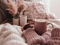 A cup of coffee and a pair of mittens on a bed. Generative AI image. Royalty Free Stock Photo