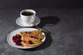 A cup of coffee and pancakes with berries on a teel. Delicious breakfast