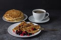 A cup of coffee and pancakes with berries on a teel. Delicious breakfast