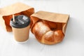 Cup of coffee and pastry in paper bags