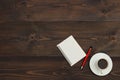 Cup of coffee, pen and pocketbook on wooden desktop. View from above