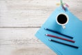 Cup of coffee with pencils on blue paper Royalty Free Stock Photo