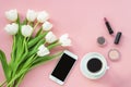 Cup of coffee, phone, cosmetics and bouquet of tulips on pink background, top view. Women's day or Mother's day concept Royalty Free Stock Photo