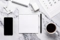 Cup of coffee, phone, headphones, calendar and notebook paper on the marble table. Flat design, planning concept, goal setting,