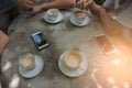 Cup coffee and phone on the table in coffee shop at morning