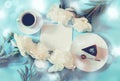 Cup of coffee, piece of cake, white peony flowers and empty card for your text on blue background.