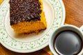 A cup of coffee with a piece of carrot cake inside a plate. Royalty Free Stock Photo