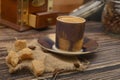 A Cup of coffee, pieces of brown sugar in a sugar bowl, coffee beans in a glass jar, a coffee grinder on a wooden background. Royalty Free Stock Photo